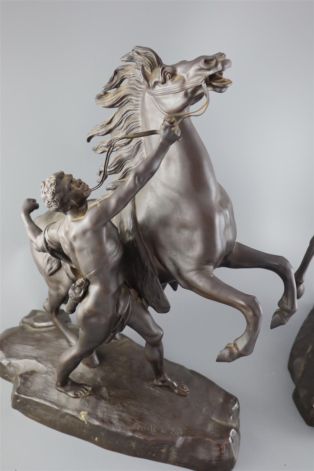 After Guillaume Coustou the Elder (French 1677-1746). A pair of bronze Chevaux de Marly, height 19in.